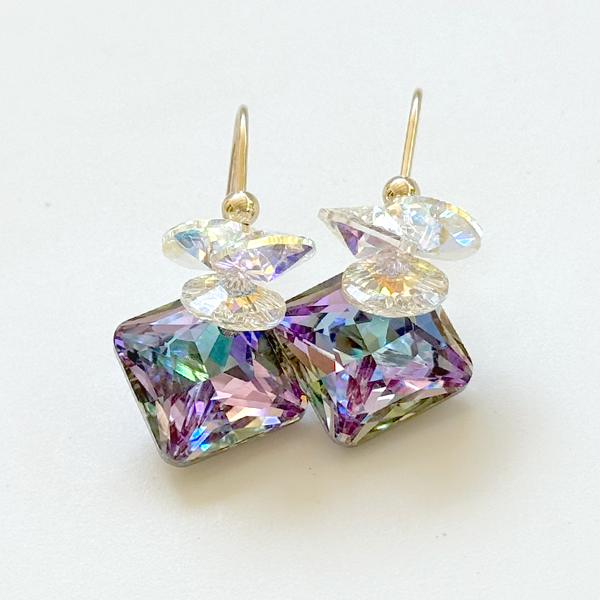 A pair of drop earrings featuring iridescent circular clusters with a 16mm princess cut crystals, in a multicolor setting.