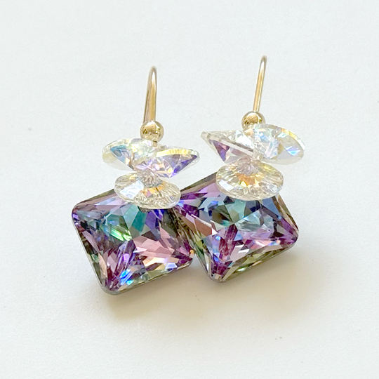 A pair of drop earrings featuring iridescent circular clusters with a 16mm princess cut crystals, in a multicolor setting.