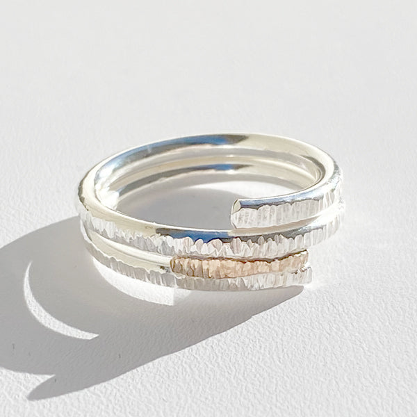 A close-up image of a mixed metals ring featuring 14 karat yellow gold on Argentium silver, displaying its textured surface on a white background. Handmade by Artist Lisa Ramos