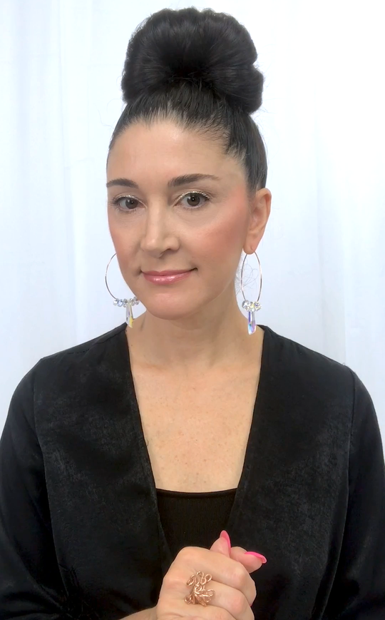 Designer, Lisa Ramos wearing crystal hoop earrings.  