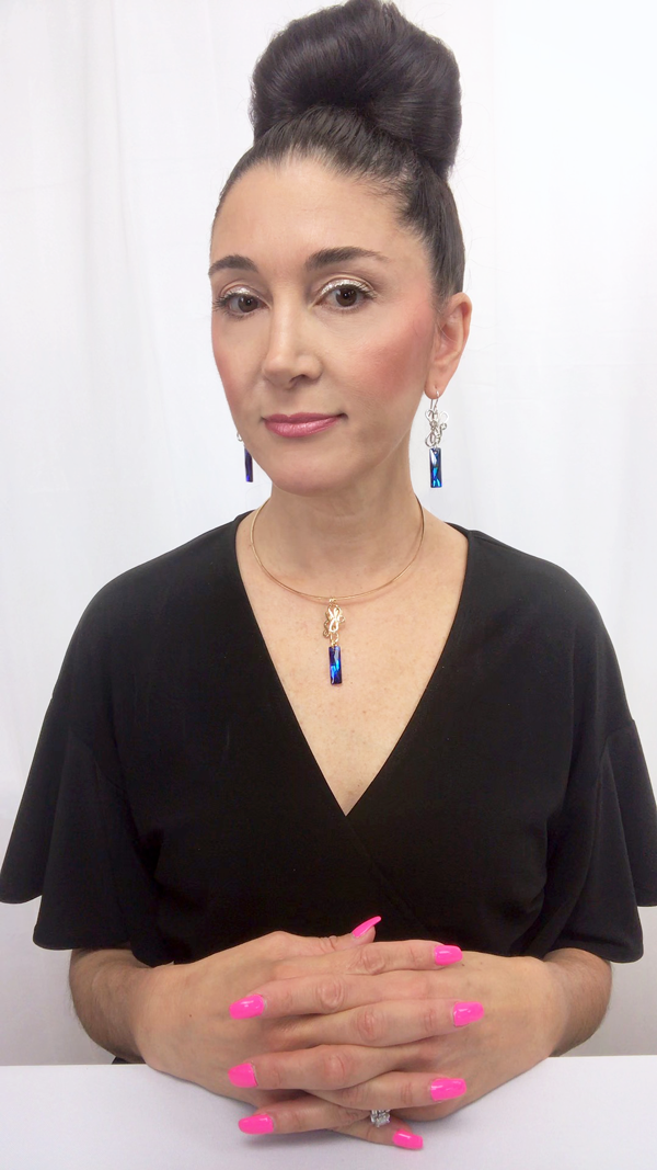 Designer, Lisa Ramos showcasing a the blue pendant.  